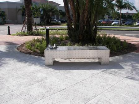 Abstract bench design in paved area under a tree
